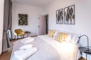 a bedroom with a large white bed with pillows at Villa Muralto Rooms & Garden in Locarno