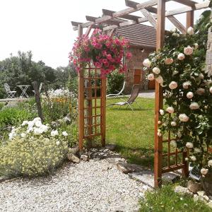 einen Garten mit einem Tor mit Blumen darauf in der Unterkunft La Belle Âme in Saint-Priest-des-Champs