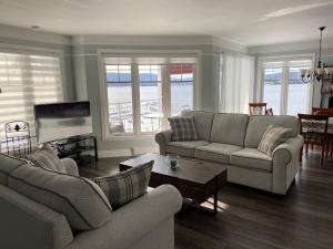 a living room with two couches and a table at Condo Lac Archambault 298 in Saint-Donat-de-Montcalm