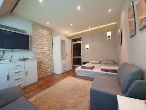 een woonkamer met 2 bedden en een flatscreen-tv bij Apartment For You in Varna