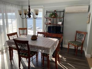 een eetkamer met een tafel en stoelen en een kamer met een raam bij Condo Lac Archambault 298 in Saint-Donat-de-Montcalm