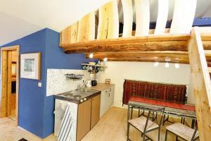 a kitchen with blue walls and a wooden staircase at Ferienwohnung Hofkastanie 