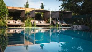 - une piscine avec des chaises longues à côté d'une maison dans l'établissement Le Parc Hôtel Obernai & Yonaguni Spa, à Obernai