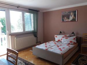 sypialnia z łóżkiem ozdobionym czerwonymi kwiatami w obiekcie Smx Apartement w mieście Prelog