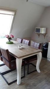 a dining room table with chairs and a vase of flowers at Anna in Nunspeet