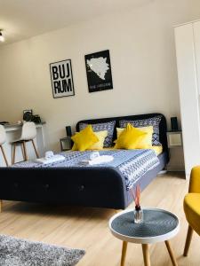 Un dormitorio con una cama con almohadas amarillas y una mesa. en Dream Apartments, en Mostar