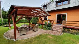 a wooden pavilion with a table and chairs in a yard at Domek Eve in Giżycko