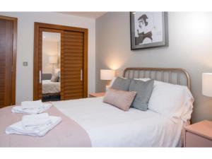a bedroom with a large white bed with a mirror at The Most Central Apartment in Cardiff in Cardiff