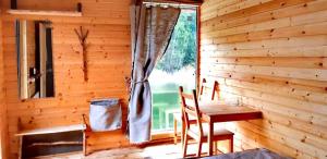 Habitación de madera con mesa, sillas y ventana en Ethno-Usadba, en Trusovo