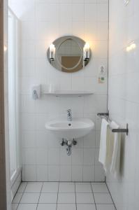 a bathroom with a sink, mirror, and toilet at Hotel Papillon in Budapest
