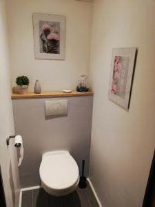 a small bathroom with a white toilet and flowers at La Citadelle charme et authenticité in Lorgues