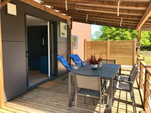a patio with a table and chairs on a deck at Cottage du garlai in Bressuire
