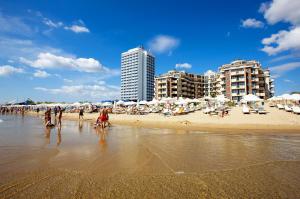 un grupo de personas en una playa con sombrillas en Hotel Golden Ina en Sunny Beach