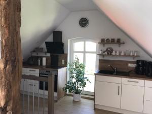 uma cozinha com armários brancos e uma janela em Ferienhof Kleemann em Barßel