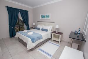 een slaapkamer met een bed met twee zwanen erop bij Van Den Berg's Guesthouse in Bettyʼs Bay