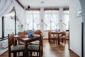 a dining room with tables and chairs and windows at Hotel Carpati in Gura Humorului