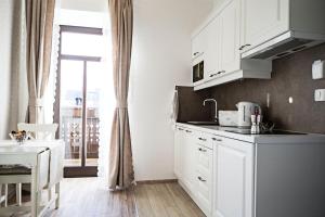 a kitchen with white cabinets and a large window at Vila Mila in Bled