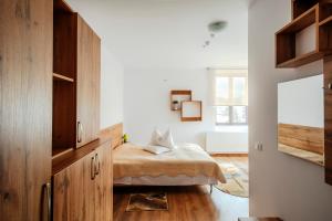 a bedroom with a bed with a wooden cabinet at Hotel Carpati in Gura Humorului