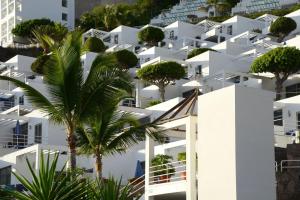 a white building with trees in front of it at Bahia Blanca in Puerto Rico de Gran Canaria