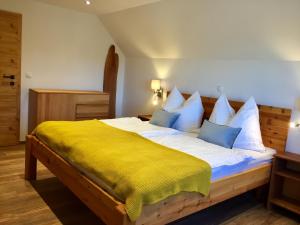 a bedroom with a large bed with a yellow blanket at Ferienhaus Trausibauer in Stainz