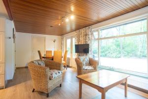 a living room with a table and chairs at Bungalowpark Vogelenzang in Lage Mierde