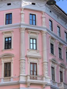 得利雅斯特的住宿－Alessia Deluxe，粉红色的建筑,有白色的柱子和窗户
