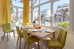 a dining room with a table and chairs and windows at Villa Meeresgruss in Ostseebad Sellin
