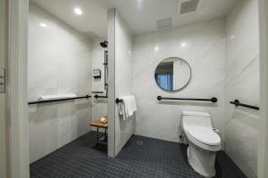 a bathroom with a toilet and a mirror at Pestana Park Avenue in New York