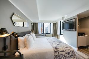 a bedroom with a large bed and a tv at Pestana Park Avenue in New York