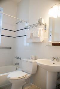 a white bathroom with a toilet and a sink at Casa Marina Hotel & Restaurant - Jacksonville Beach in Jacksonville Beach
