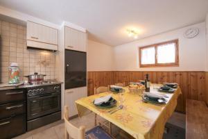 a kitchen with a table with a yellow table cloth at Chalet La Caleche in La Tzoumaz