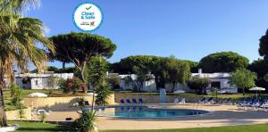 a resort with a swimming pool with chairs and trees at Prado Villas in Vilamoura