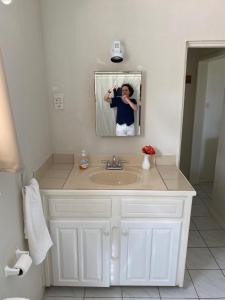 a person taking a picture of a bathroom sink at Castles In Paradise Villa Resort in Vieux Fort