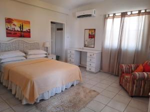 a bedroom with a bed and a desk and a chair at Castles In Paradise Villa Resort in Vieux Fort