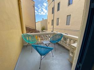 a balcony with two chairs and a table at Hotel Majestic in Nîmes