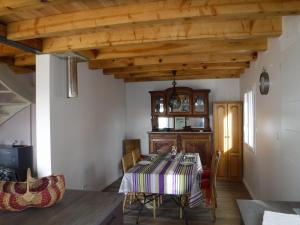 een eetkamer met een tafel en een houten plafond bij Gîte Lou Saltret in Montbel