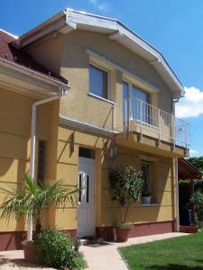 a yellow house with a porch and a balcony at Akacia Apartment - FREE PARKING INSIDE OUTSIDE 2 bedrooms garden next to centre in Budapest