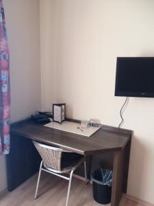 a wooden desk with a chair and a computer monitor at Hotel Köln-Bonn in Bornheim