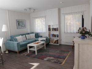 een woonkamer met een blauwe bank en een tafel bij Ferienhaus Gregor in Birkenwerder