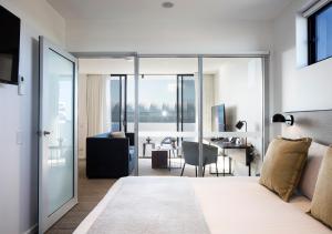 a bedroom with a bed and a living room at Quest Robina in Gold Coast