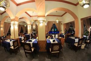 a dining room with blue tables and chairs and a mirror at Oriental Rivoli Hotel & Spa in Sharm El Sheikh