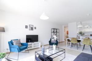 sala de estar con sillas azules y mesa en Nice apartment ideally located in Martigny, en Martigny-Ville
