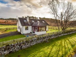 ein kleines weißes Haus mit einer Steinmauer in der Unterkunft Borgan Cottage in Newton Stewart