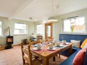 uma sala de jantar com uma mesa e uma lareira em Borgan Cottage em Newton Stewart