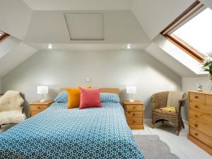 ein Schlafzimmer mit einem großen Bett mit bunten Kissen in der Unterkunft Borgan Cottage in Newton Stewart