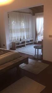 1 dormitorio con 1 cama y una ventana con cortinas en Villa Caterina, en Monte Petrosu