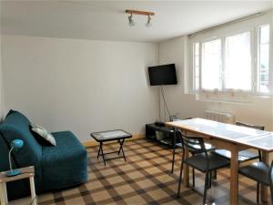 een woonkamer met een tafel en een bank en een tafel en stoelen bij Appartement Bel Etre Langeais in Langeais