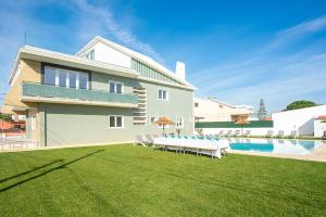 uma casa com um quintal com piscina e cadeiras em Villa Mena em Barriga