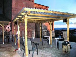 a wooden pergola on a patio with chairs and tables at Complejo Rural Lifara in Aniñon