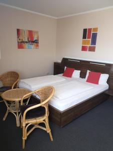 Schlafzimmer mit einem Bett mit 2 Stühlen und einem Tisch in der Unterkunft Hotel Köln-Bonn in Bornheim